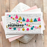 Handmade greeting card of party tassel garlands and time to celebrate sentiment on card with cards in background.