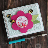 Handmade greeting card with flower on it and miss your face sentiment on it with bumble bees flying around the flowers.