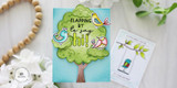 Handmade greeting card with doodle birds in tree with flapping by to say hi sentiment with crafting supplies in background.