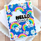 Handmade greeting card of rainbows and flowers and hello friend sentiment with cardstock in background.