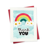 Handmade greeting card with rainbow and flowers with thank you sentiment with cardstock in background.