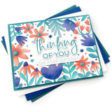 Handmade greeting card with flowers on it and thinking of you on your birthday sentiment on it with cardstock in background.