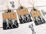Handmade gift tags with dancing skeletons in graveyards on each of them.