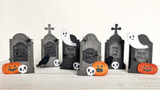 Several treat boxes with ghosts and pumpkins on them with halloween sentiments on each.