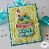 Handmade greeting card with cupcake on it and happy birthday sentiment on it with party materials in background.