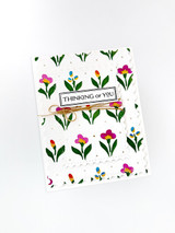 Handmade greeting card with flowers on it and thinking of you sentiment on it.