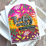 Handmade greeting card with colorful flowers on it and thinking of you as you recover sentiments on it with cardstock in background.