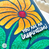 Close up of a handmade greeting card of a flower with you are an inspiration sentiment on it.