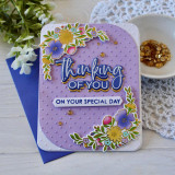 Handmade greeting card with flowers on it and thinking of you on your special day sentiments on it with crafting materials in background.