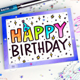 Handmade greeting card with dots on it and birthday decor with happy birthday sentiment on it with crafting materials in the background.