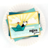 Handmade greeting card with dog in a paper boat with a bird and miss you sentiment on it.