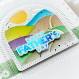Handmade card with happy father's day sentiment on colorful rolling hills background in an arched frame.