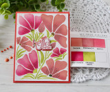 Handmade greeting card with flowers on it and hello there sentiment on it with crafting materials in background.