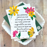 Handmade greeting card with flowers on it and sentiment about strength and capability on it with cardstock in background.