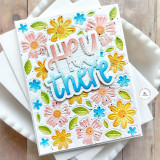 Handmade greeting card with flowers on it and hey there sentiment with cardstock in background.