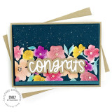 Handmade floral greeting card with congrats sentiment on it with cardstock in background.