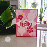 Handmade greeting card with hello sentiment with flowers in background.