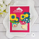 Handmade greeting card with mushrooms, flowers, and snails on it with you've got snail mail sentiment on it with flowers in background.
