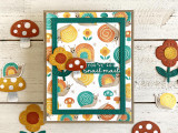 Handmade greeting card with mushrooms, flowers, and snails with you've got snail mail sentiment on it with mushrooms, flowers, and snails in the background.