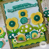 Handmade greeting card with mushrooms, flowers, and snails with sorry I'm slow... happy belated birthday sentiment on it with mushrooms and flowers in background.