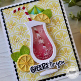 Handmade greeting card with a drink cup, citrus fruit, and cheers to you sentiment on it with flowers in the background.