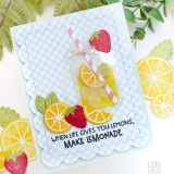 Handmade greeting card with a drink cup, citrus fruit, and when life gives you lemons, make lemonade sentiment on it with paper craft citrus fruit in background.