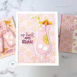 Handmade greeting card with a drink cup, citrus fruit, and sip back and relax sentiment on it with cards in the background.