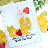 Handmade greeting card with a drink cup, citrus fruit, and when life gives you lemons, make lemonade sentiment on it with paper craft citrus fruit in background.