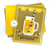 Handmade greeting card with drink cup, citrus fruit, and when life gives you lemons, make lemonade sentiment on it with cardstock in the background.