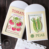 Two handmade greeting card gift holders, one with tomatoes on it and grown with love sentiment and the other with two peas on it with card in the background.