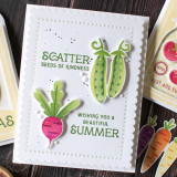 Handmade greeting card with two peas and scatter seeds of kindness sentiment on it and a radish with wishing you a beautiful summer sentiment on it with crafting materials in the background.