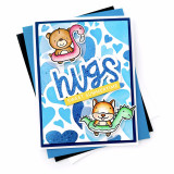 Handmade greeting card with foiled hearts on it and hugs sweet summertime sentiments on it with cardstock in background.