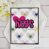 Handmade greeting card with colorful hearts on it and hugs you're amazing sentiments on it with flowers in background.