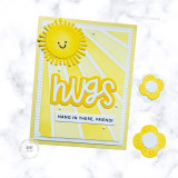Handmade greeting card with sun on it and sun rays with hugs hang in there, friend sentiments on it with crafting flowers in background.