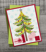 Handmade greeting card with tree on it with ornaments and a cardinal with presents underneath and season's greetings sentiment on it.