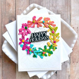 Handmade greeting card with a circle of flowers on it and happy holidays sentiment on it.