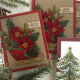 Two handmade greeting cards with flowers and sleighs on both with different holiday sentiments on each.
