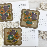 Three handmade calendars with flowers on each.