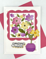 Handmade greeting card with flowers on it and sending hugs sentiment on it.
