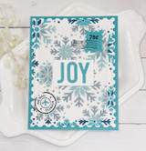 Handmade greeting card with snowflakes on it and postage stamps with joy sentiment on it.