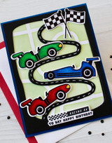 Handmade greeting card with three race cars on it and racing by to say happy birthday sentiment on it.