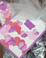 Handmade gift tag with hearts on it and sending hugs sentiment on it.