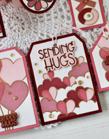 Handmade gift tag with hearts on it and sending hugs sentiment on it.