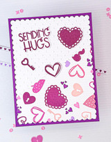 Handmade greeting card with hearts on it and a key with sending hugs sentiment on it.