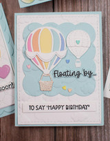 Handmade greeting card with two hot air balloons on it and floating by to say happy birthday sentiment on it.