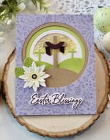 Handmade greeting card with cross in center of a meadow on it.