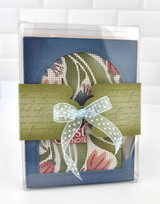 Handmade greeting card with flowers on it and tied together with a bow.