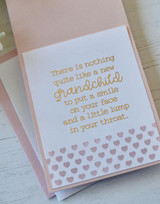 Inside of a handmade greeting card with hearts on it and a baby sentiment on it.