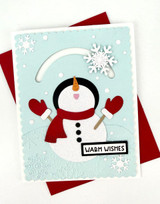 Handmade greeting card with a snowman on it and snowflakes with warm wishes sentiment on it.