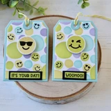 Two handmade greeting tags with smiley faces on each and different sentiments on each.
